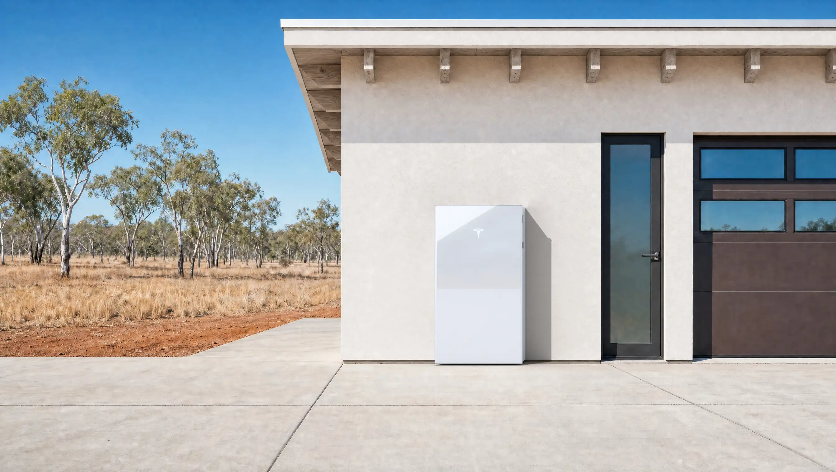 A Tesla Powerwall 3 standing against the wall of a house in Top End savanna under hard midday sun, red earth and dry spear grass beyond.